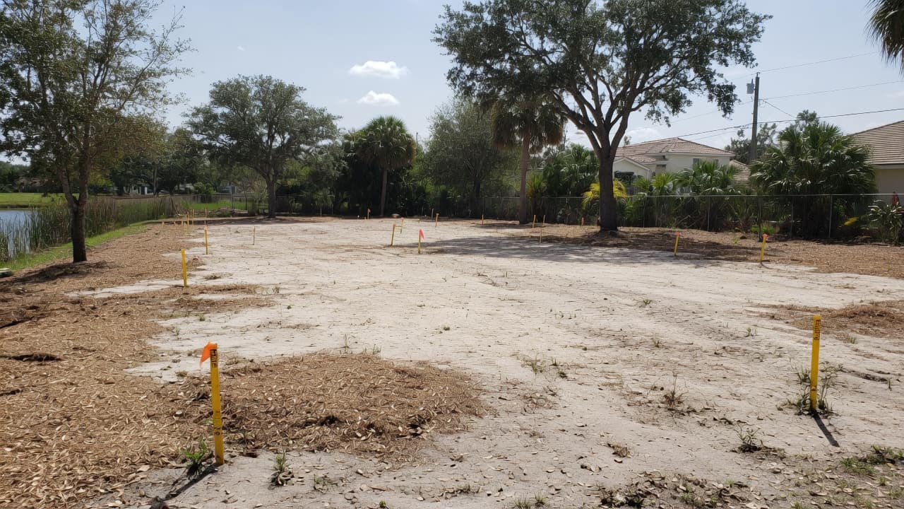 Freshly cleared Southwest Florida homesite with open sandy ground and survey stakes ready for the next step